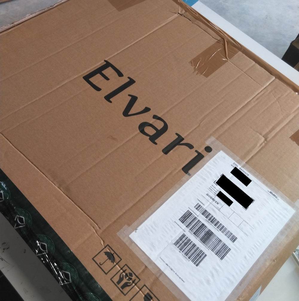 Originalverpackung der gebrauchten Kristallmatte Mini von Elvari mit Versandetikett, ideal für nachhaltigen Kauf als Rückläufer.