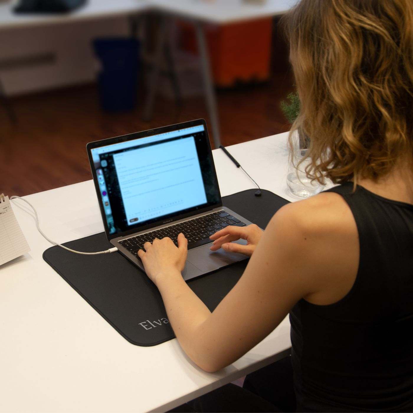 Frau arbeitet am Laptop auf Elvari® Erdungsmatte 60x40cm, ideal für grounding im Büro oder Homeoffice, Erdungsmatte online kaufen.